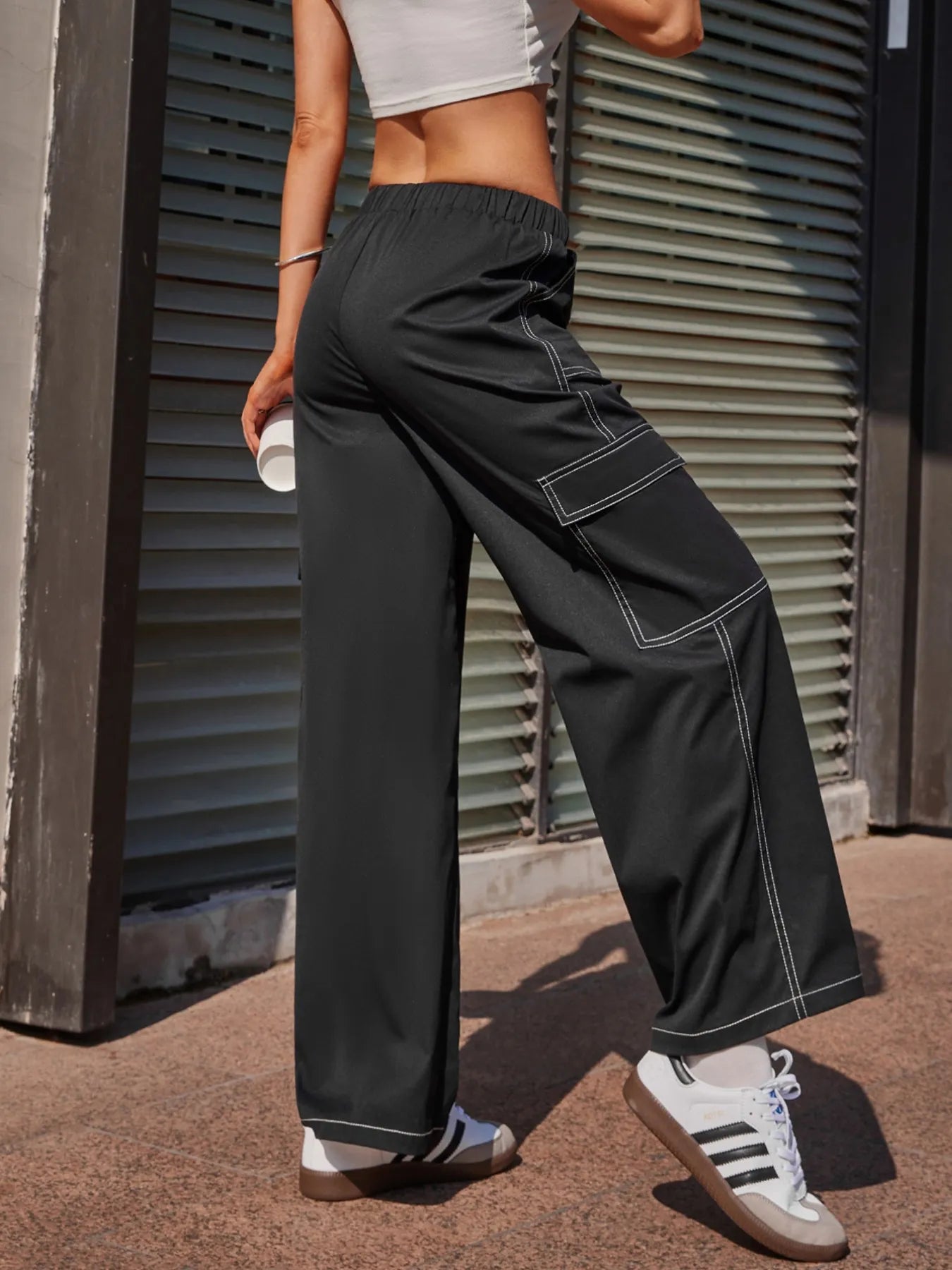 Black wide-leg pants with contrast-stitched cargo pocket panels and elastic waist