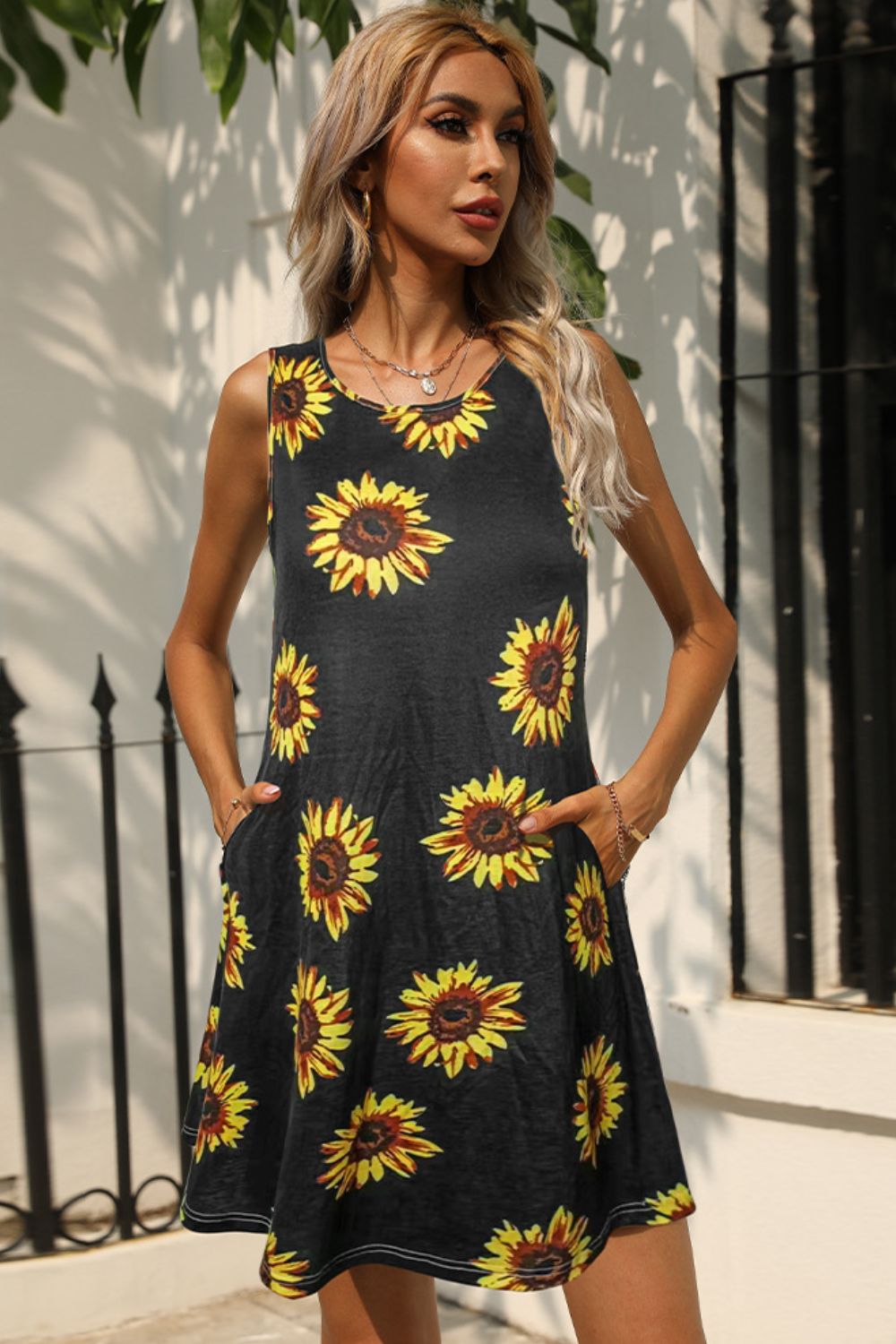 Black sleeveless dress with yellow sunflower print and round neckline