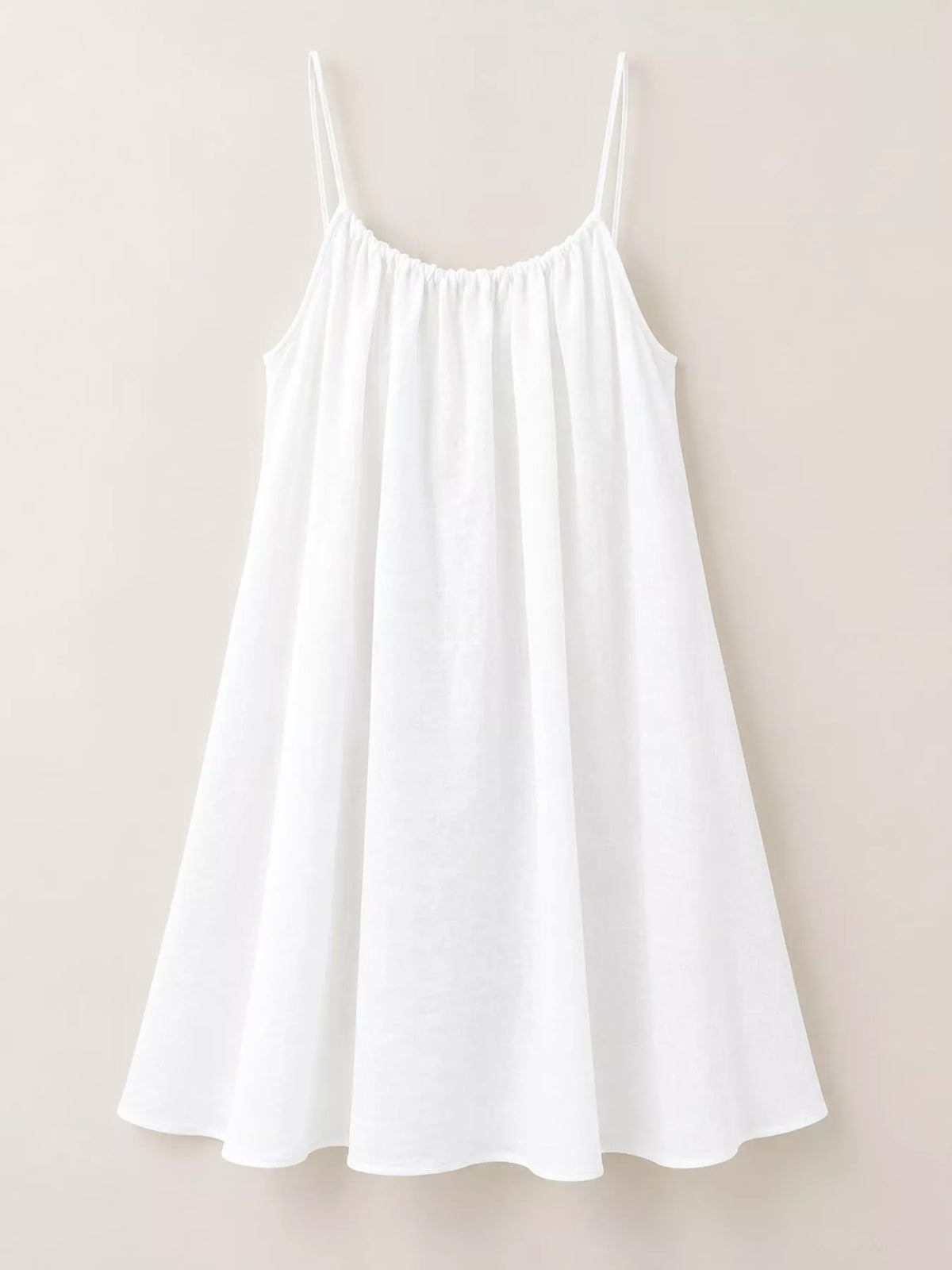 White backless mini dress with spaghetti straps and gathered, ruched bodice