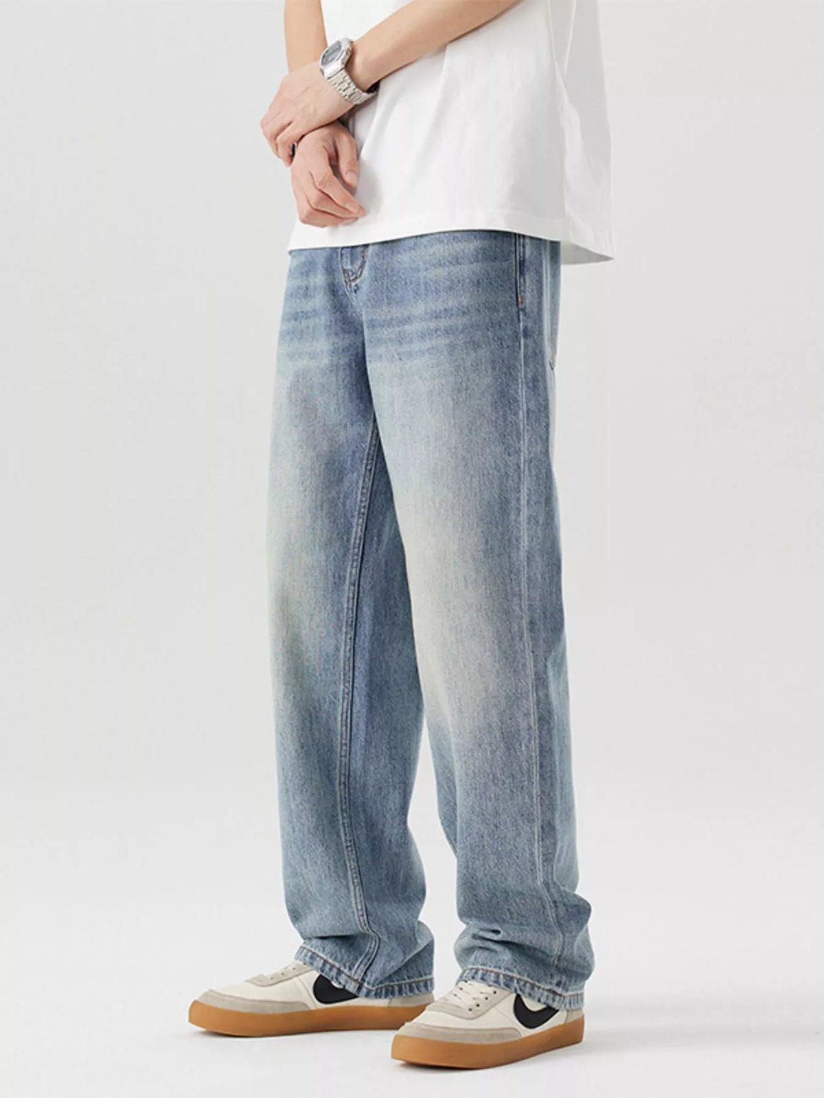 Blue loose-fit cotton jeans with vintage wash, side view and cuffed hems