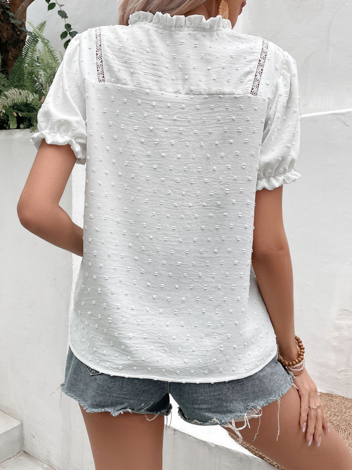 White Swiss dot blouse with puff sleeves and button front, back view