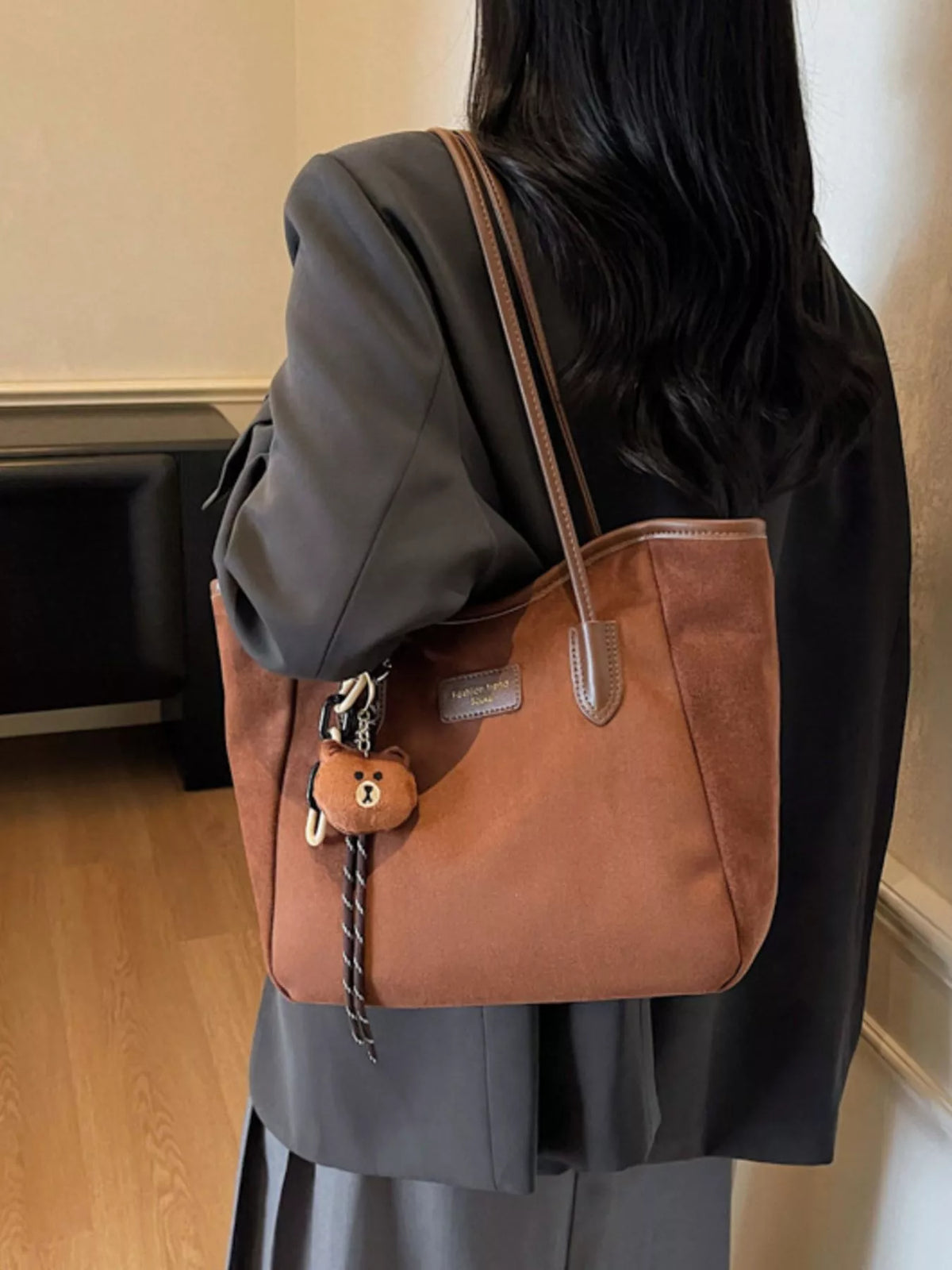 Brown suede tote bag with long shoulder straps and bear keychain charm