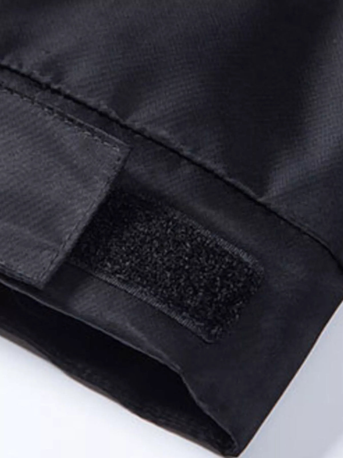 Black waterproof jacket sleeve cuff with textured patch and stitching