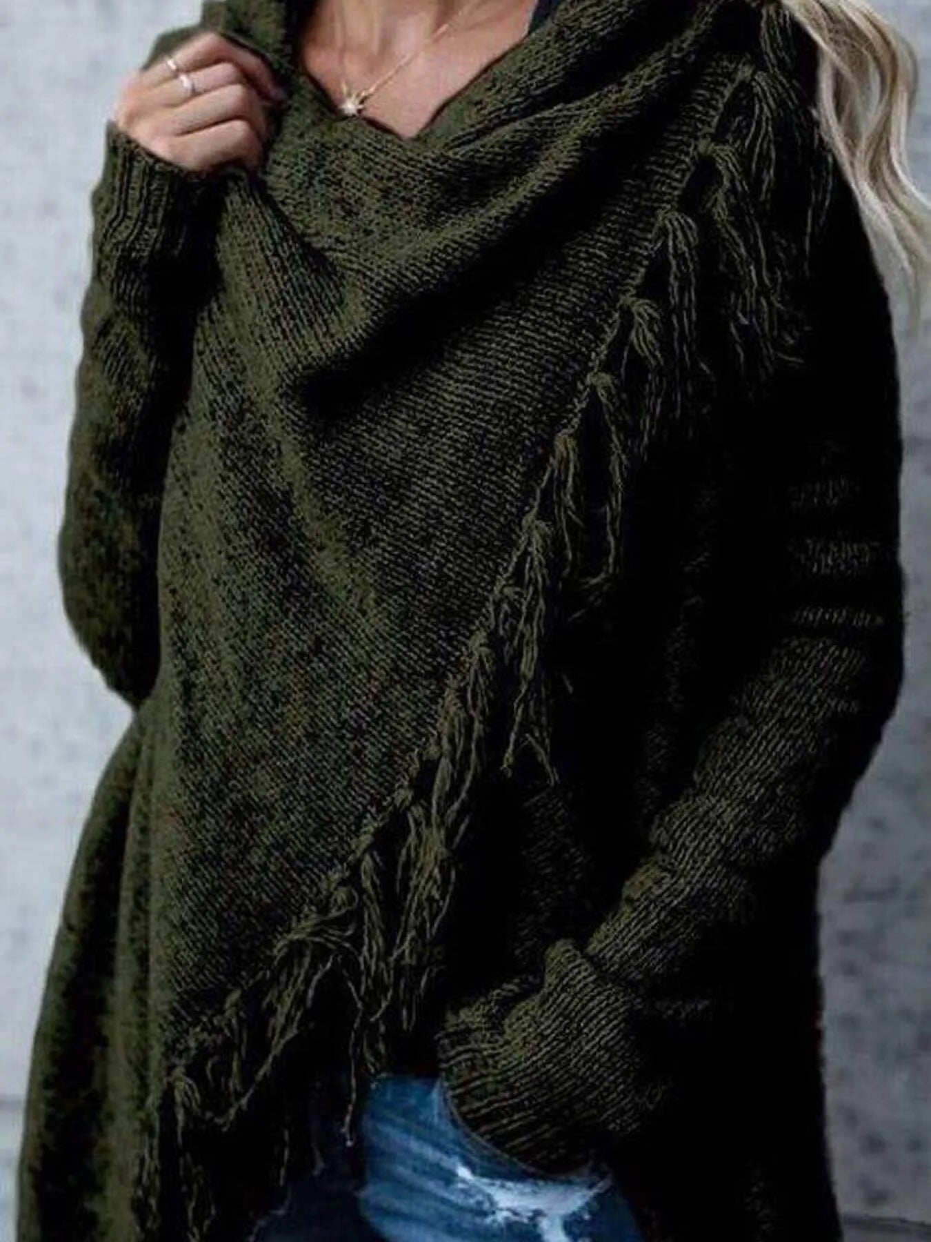 Dark green wrap cardigan close-up with long sleeves and fringe overlay