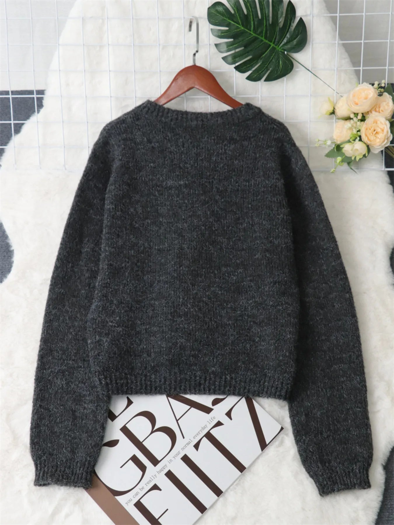 Dark gray button-up cardigan with ribbed knit texture and long sleeves, back view