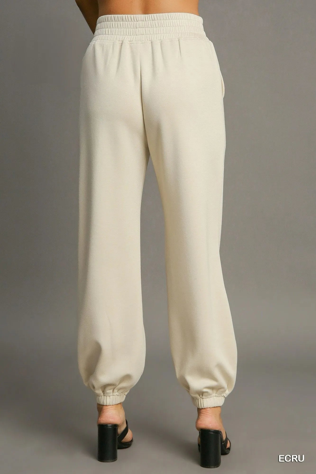 Ecru drawstring jogger pants, back view with elastic waistband and cuffed hems