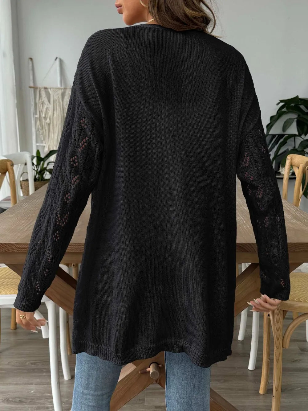 Black open-front long-sleeve cardigan with openwork lace knit and flowing hem.