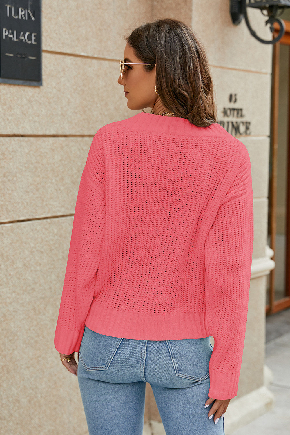 Pink openwork long-sleeve sweater with open knit texture and V-shaped back neckline