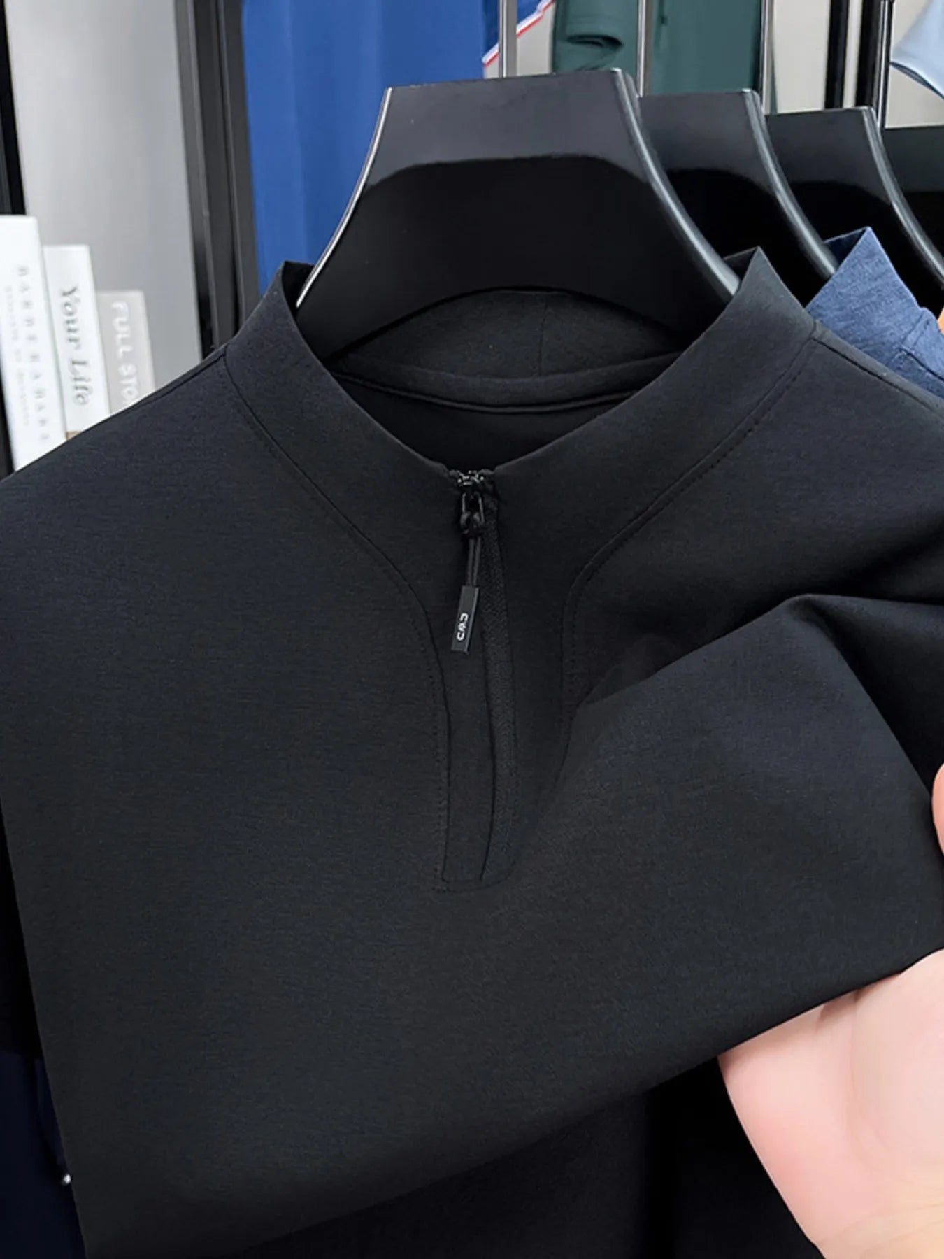 Men's quarter-zip short-sleeve top, black, close-up of zipper and collar