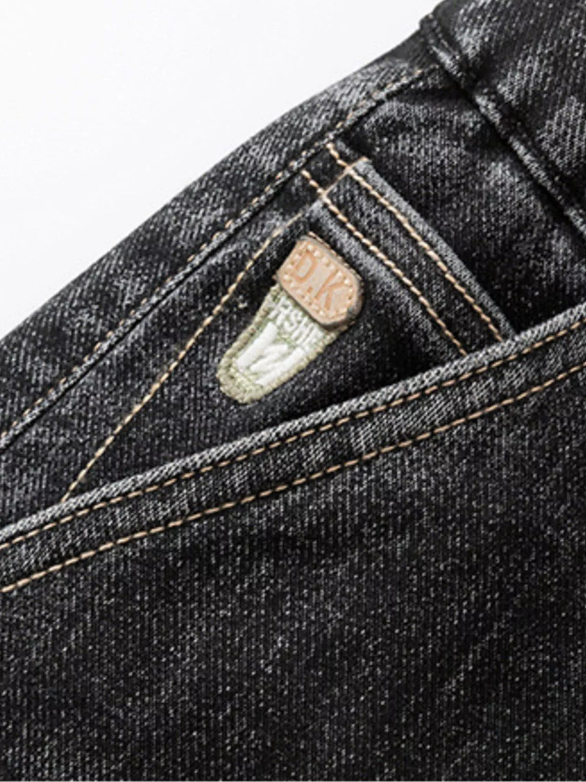 Black denim jeans with contrast topstitching and stitched logo patch on pocket