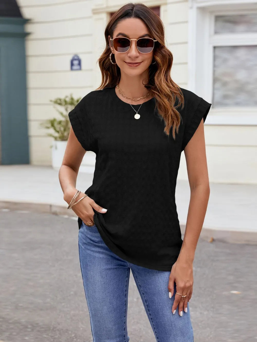 Textured round neck cap-sleeve T-shirt in black, front view with draped silhouette.