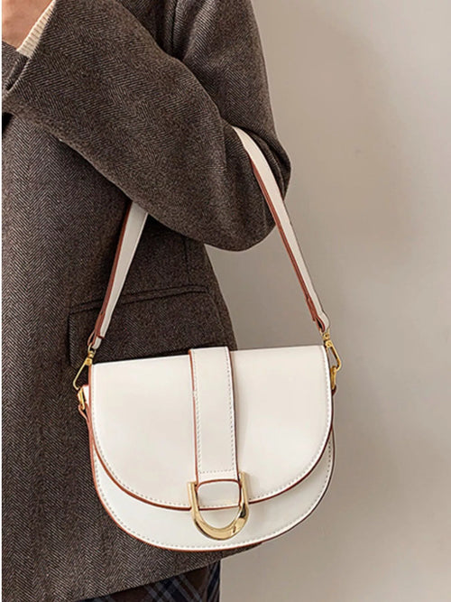 White buckle flap crossbody bag with gold-tone clasp and adjustable strap, half-moon