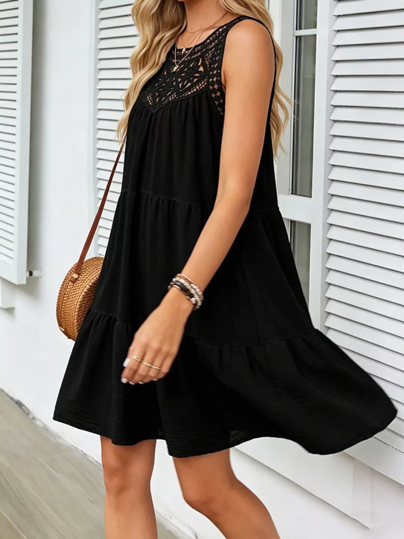 Black sleeveless lace-detail dress with tiered skirt and lace yoke