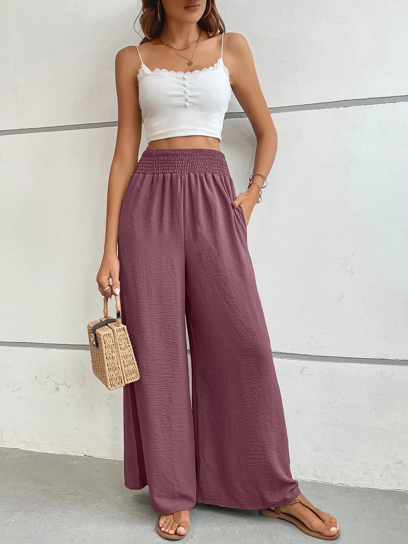 High-waisted wide-leg pants in mauve with elastic smocked waist and wide-leg silhouette.