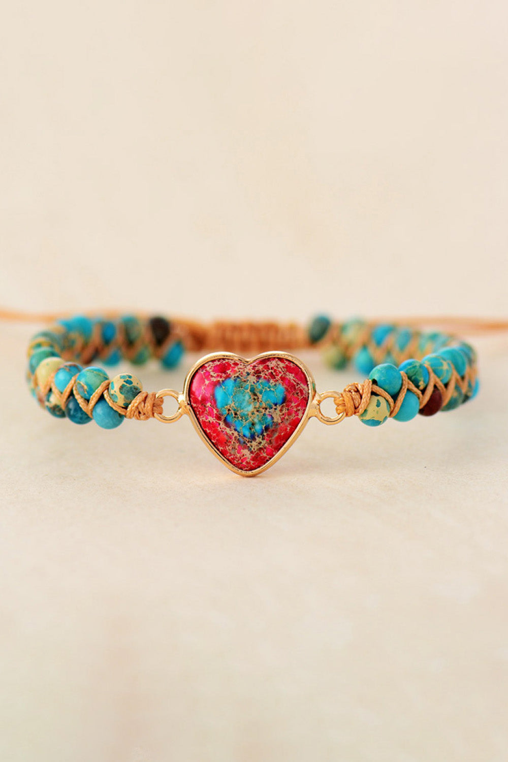 Turquoise and red beaded braided bracelet with gold-tone clasp and heart stone pendant