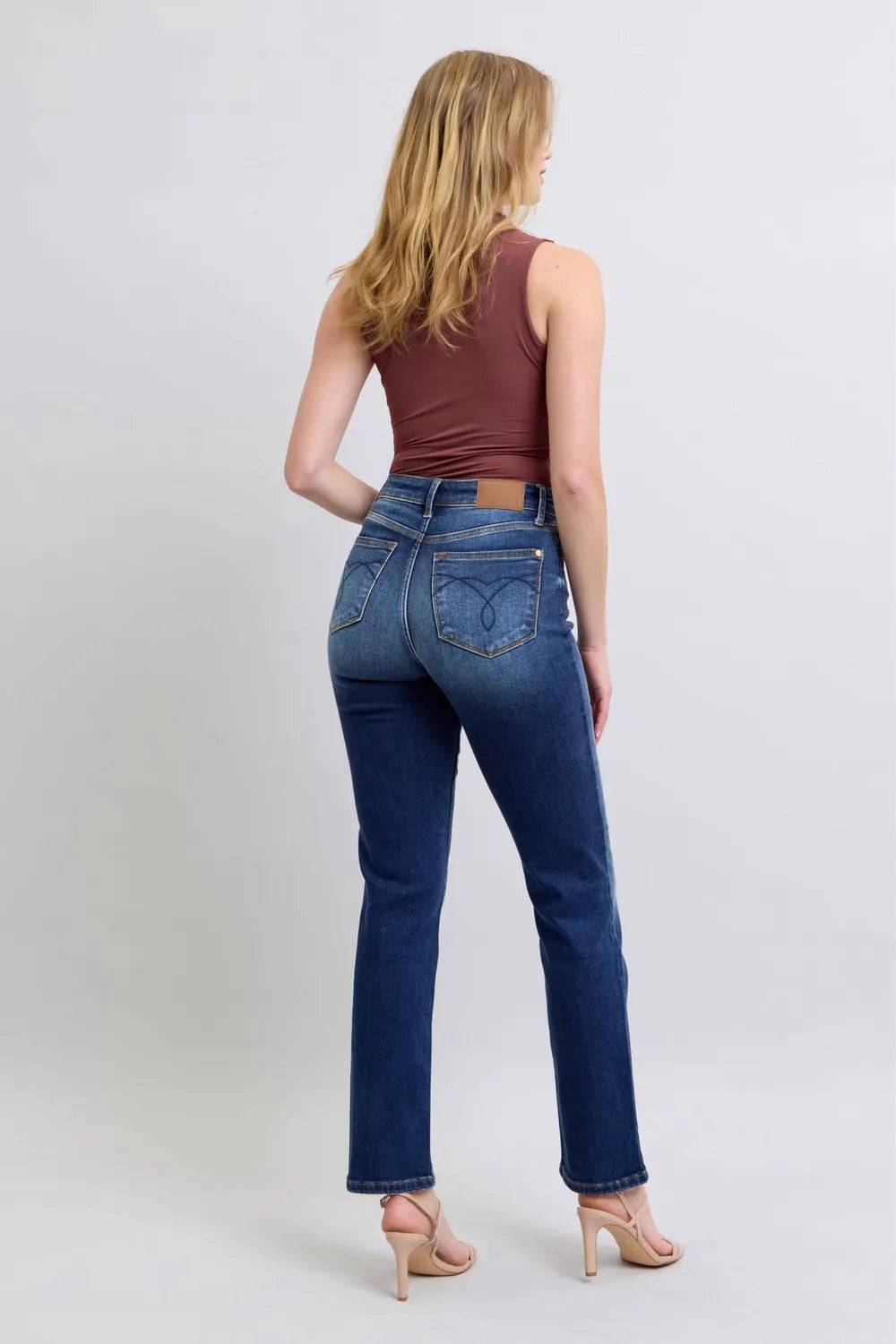 Washed dark blue straight-leg jeans, back view with pockets and stitched yoke