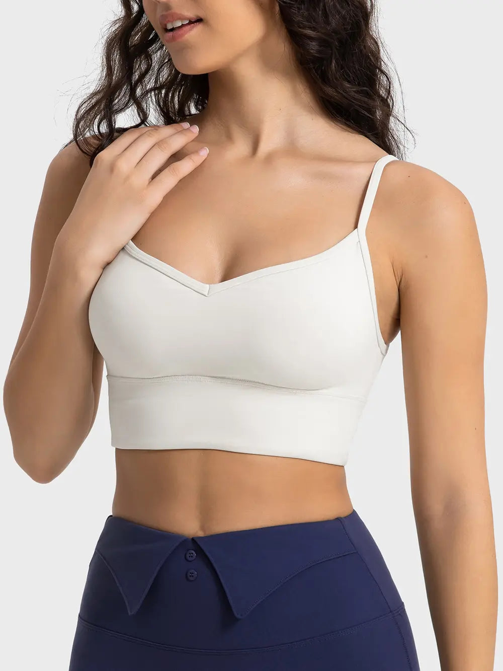 Ivory spaghetti strap sport bra with V-neckline and curved bottom hem