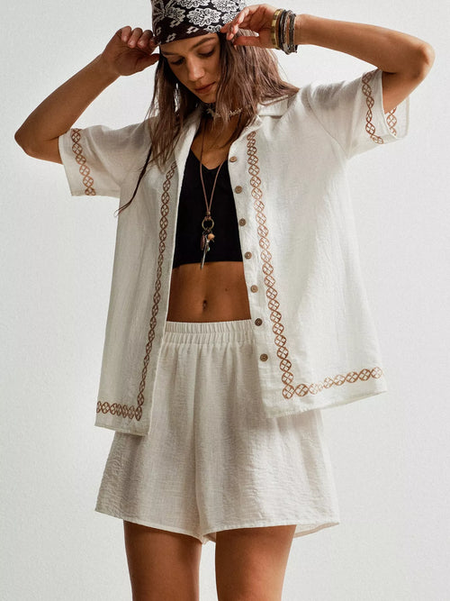 White embroidered short sleeve button-up shirt and matching shorts set, front angled view