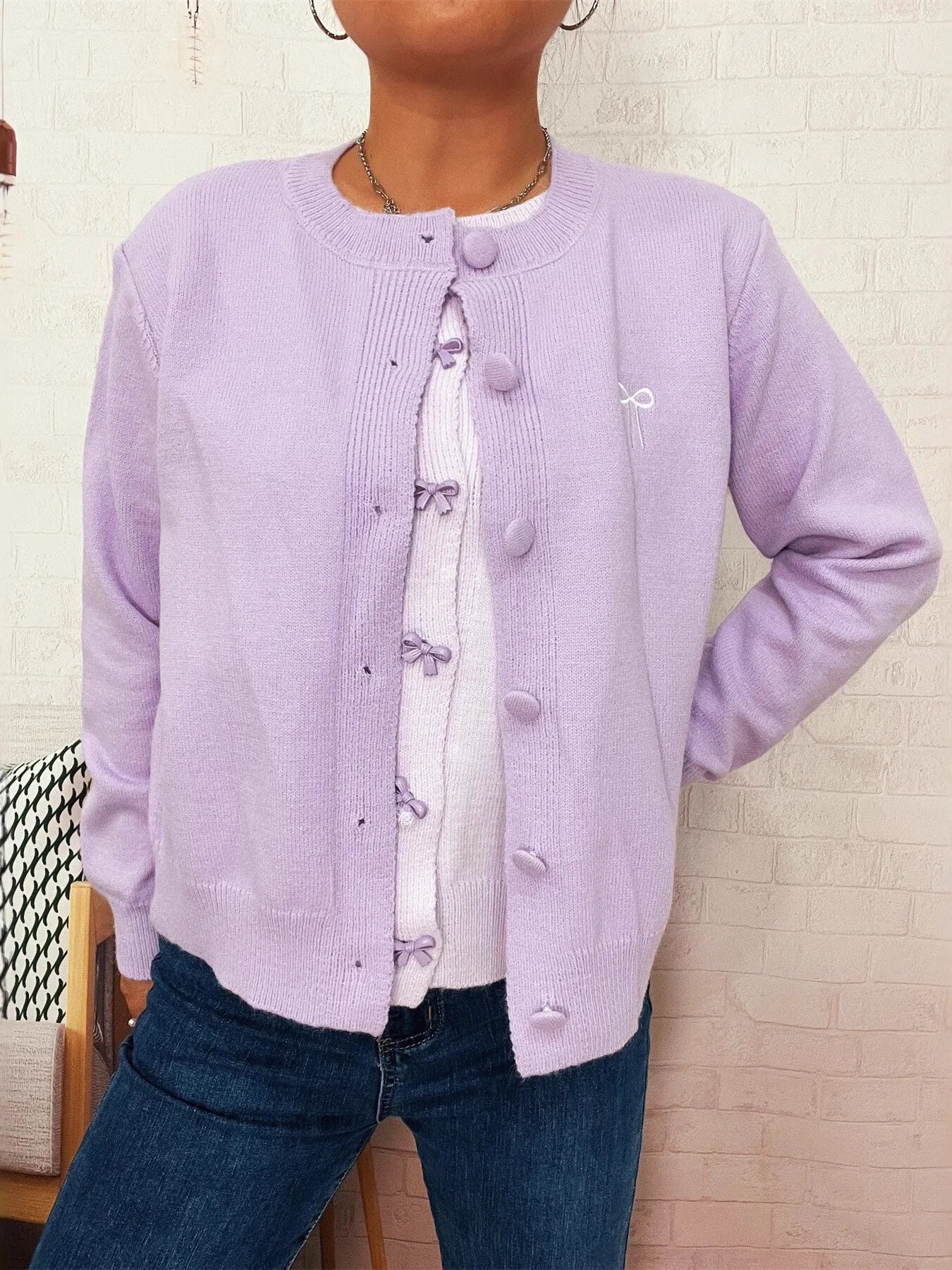 Lavender knit cardigan with button front, bow appliques, and long sleeves