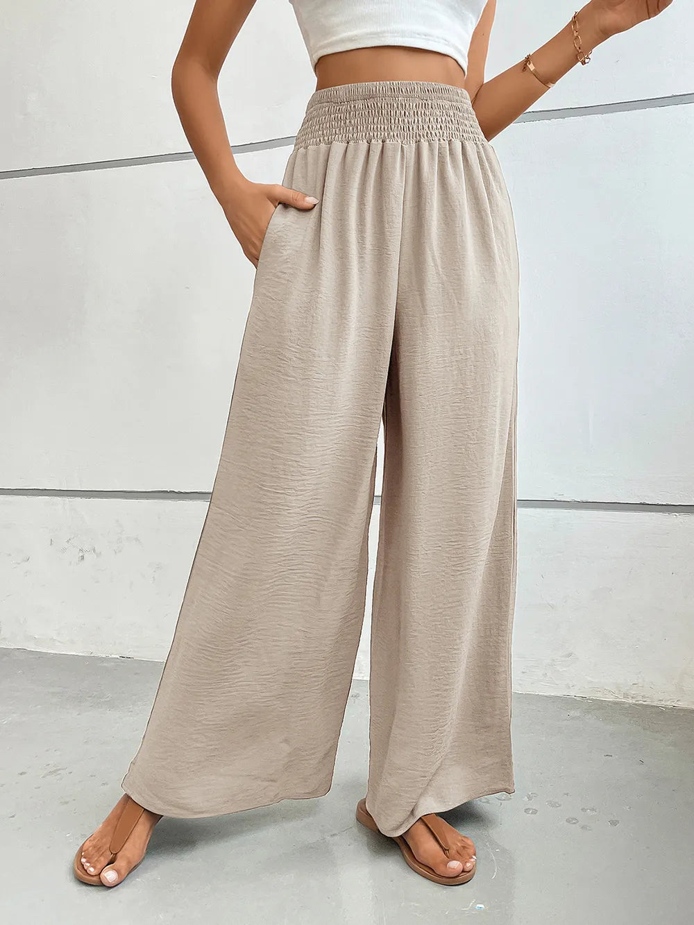 Wide-leg pants with pockets, light beige textured fabric, elastic waistband.