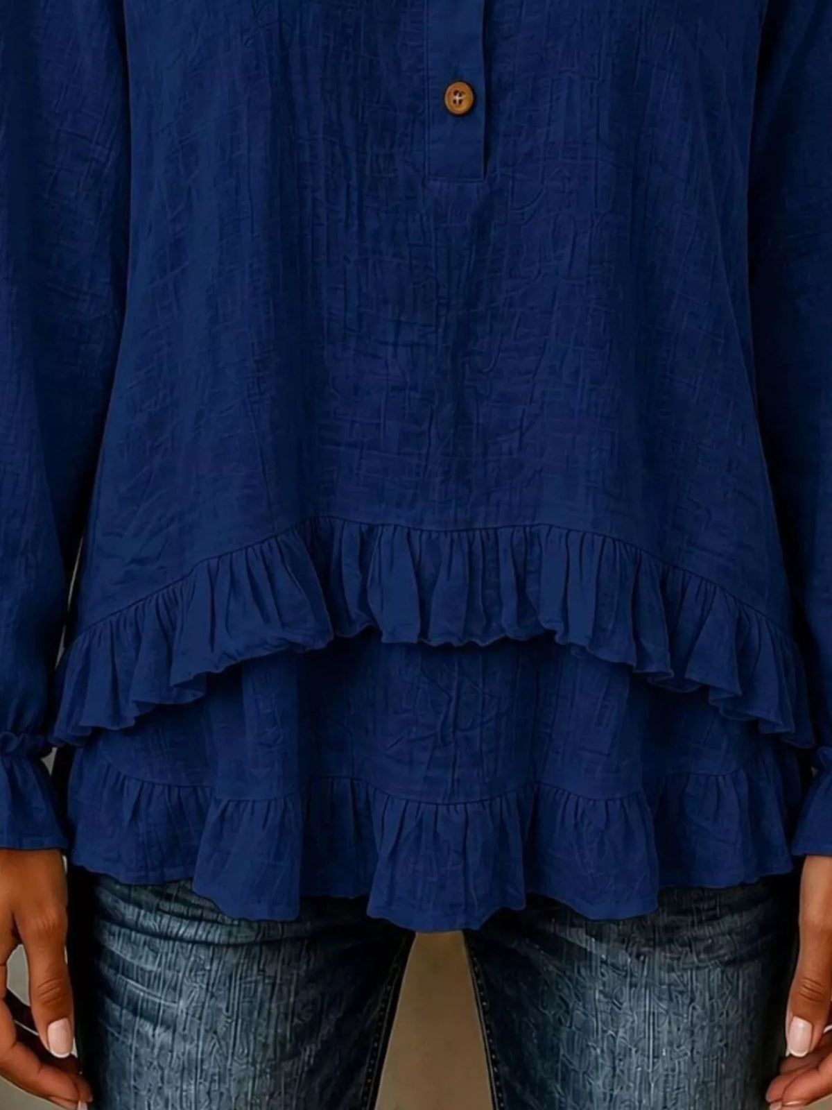 Navy long-sleeve blouse with tiered ruffles at the hem and button placket
