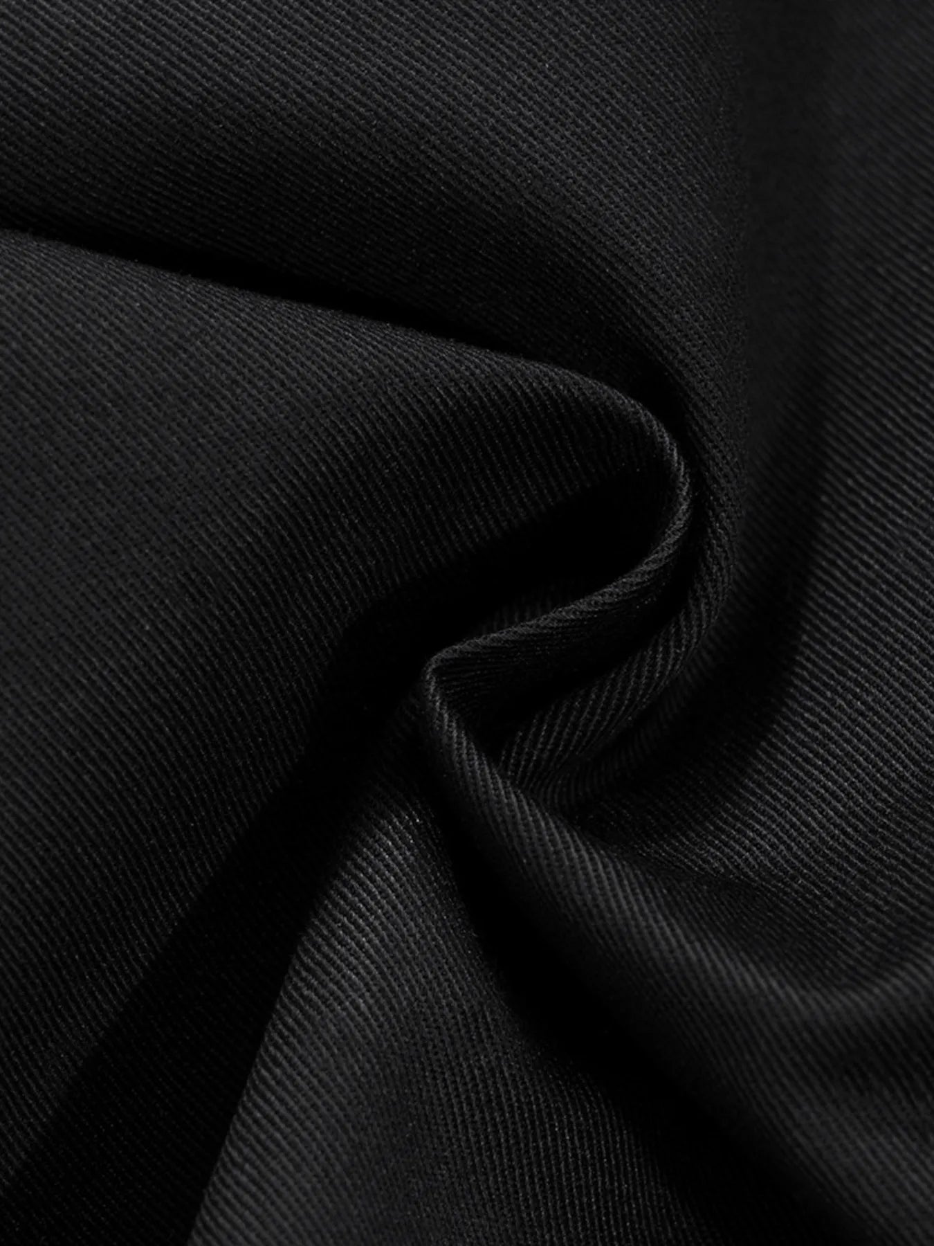 Black woven fabric close-up with textured finish and subtle grain.