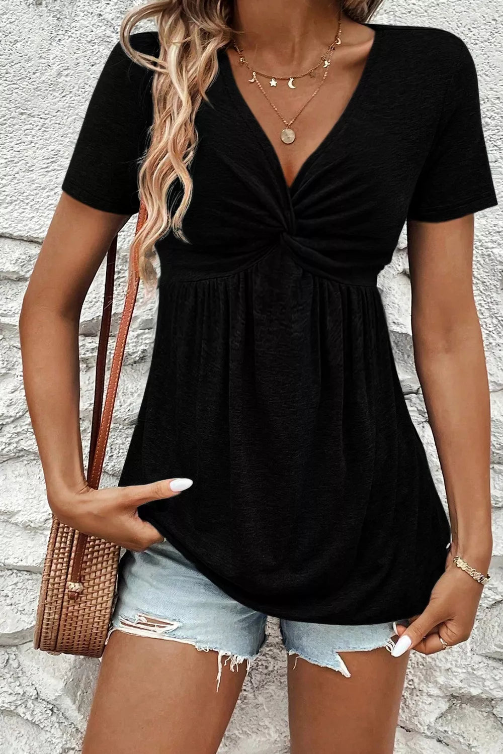 Black twist-front V-neck short-sleeve blouse with gathered waist and draped skirt.