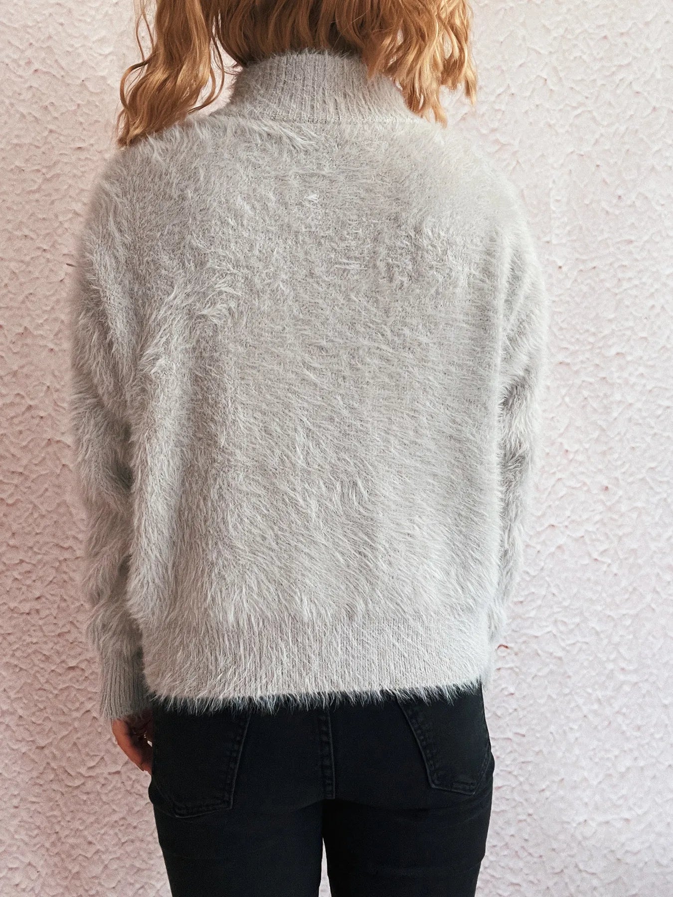 Back view of a grey fuzzy half-zip sweater with long sleeves