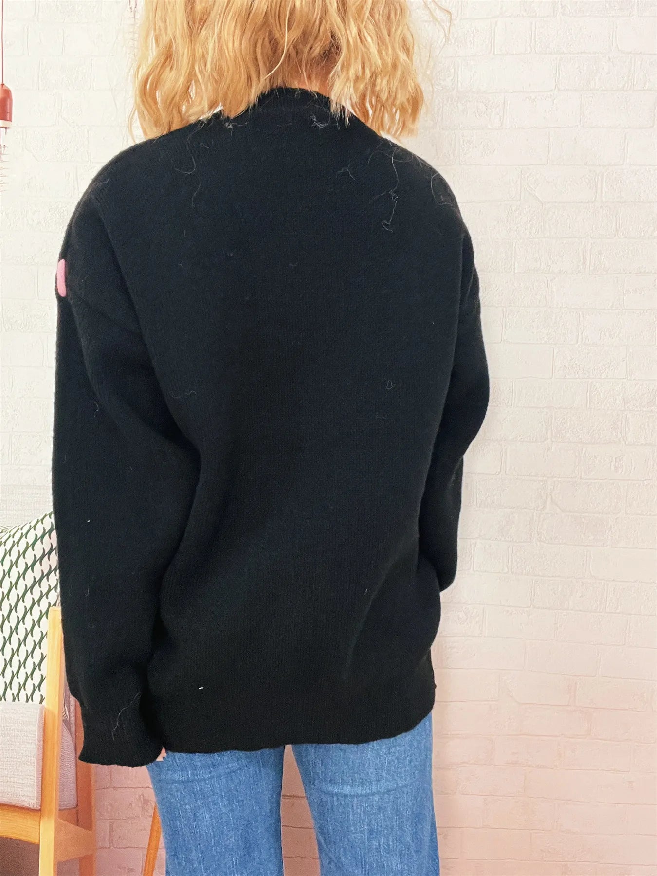 Black round-neck knit sweater with ribbed hem and cuffs, plain back view