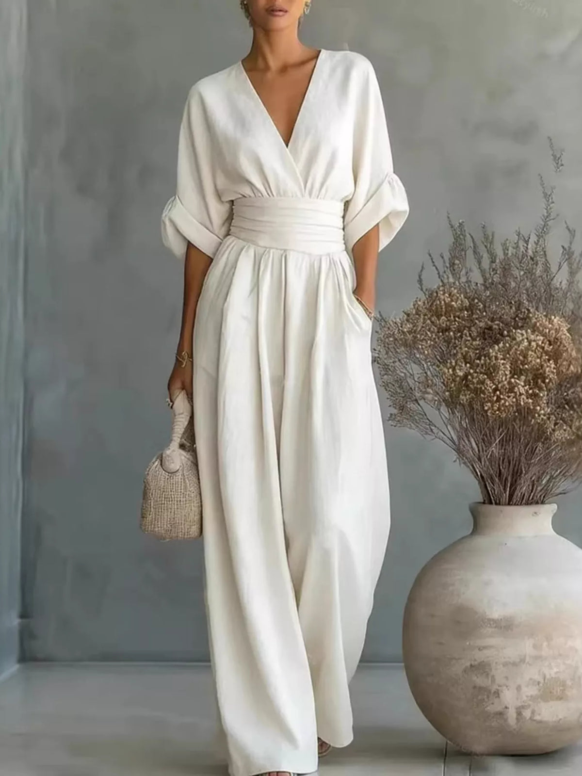 White wide-leg jumpsuit with V-neck, half sleeves, and cinched gathered waist