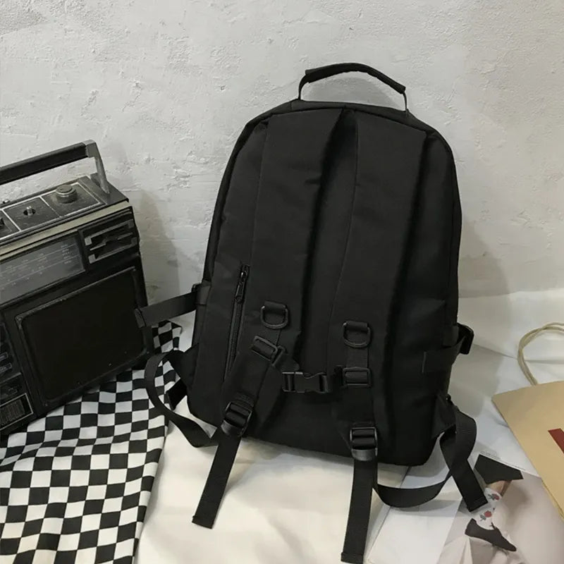 Black backpack back view with adjustable shoulder straps and padded panel