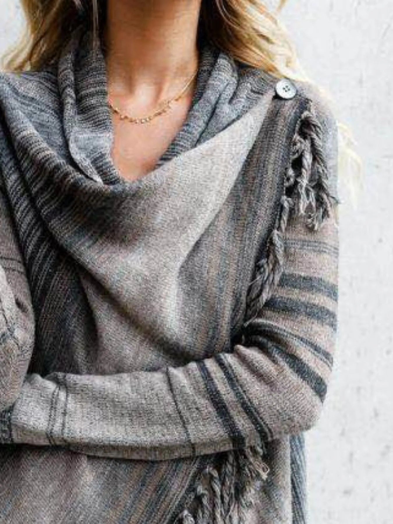 Gray striped wrap cardigan close-up with buttoned cowl neck and fringe sleeve detail