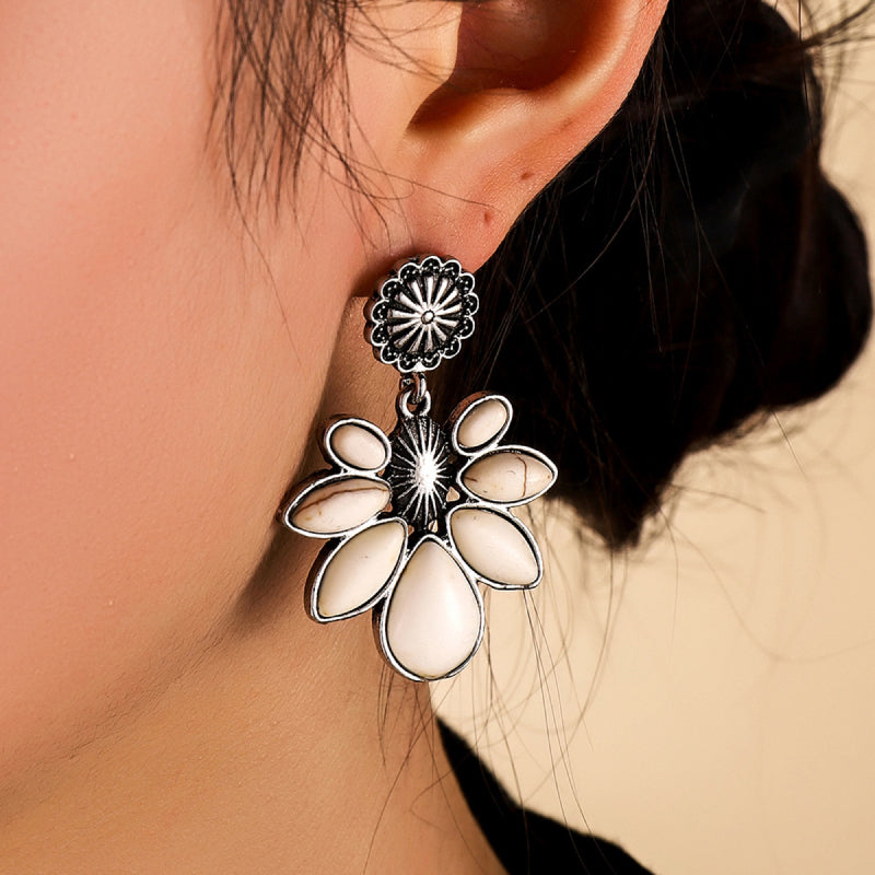 White flower drop earrings with oval white petals and a silver-tone sunburst center.