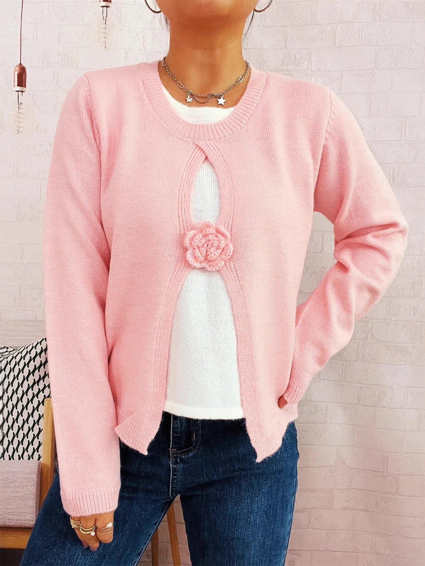Pink round-neck sweater with white underlayer keyhole and center flower detail