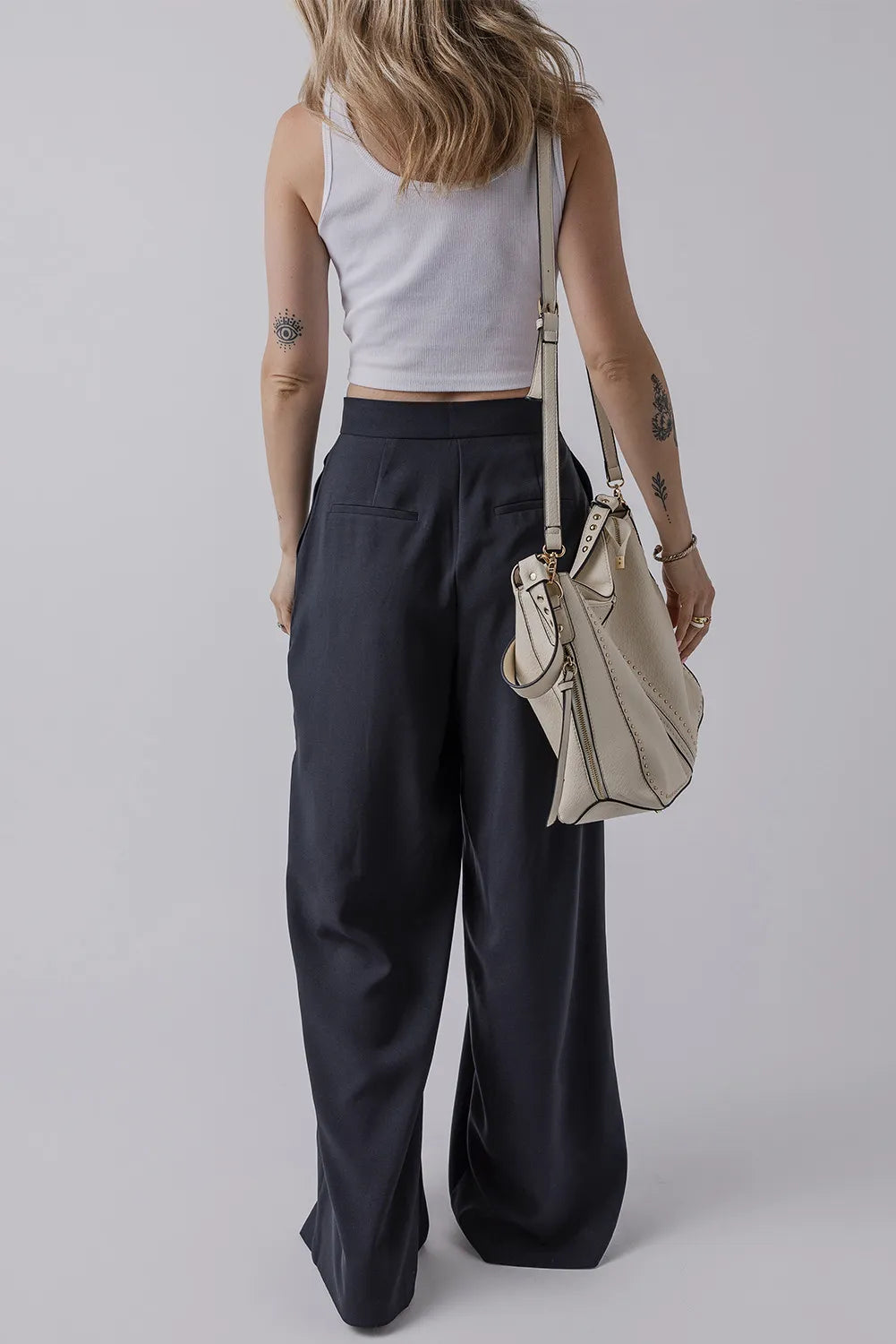 Dark navy high-waist wide-leg pants with pockets and pleated front, button closure.
