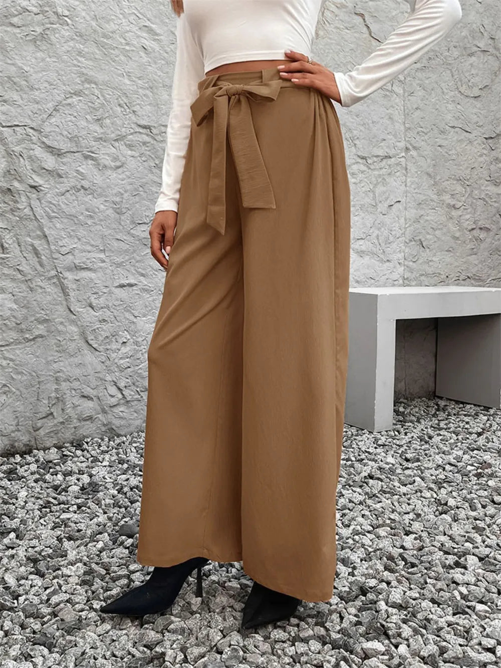 Caramel high-waist wide-leg pants with tied belt at waist, standing front
