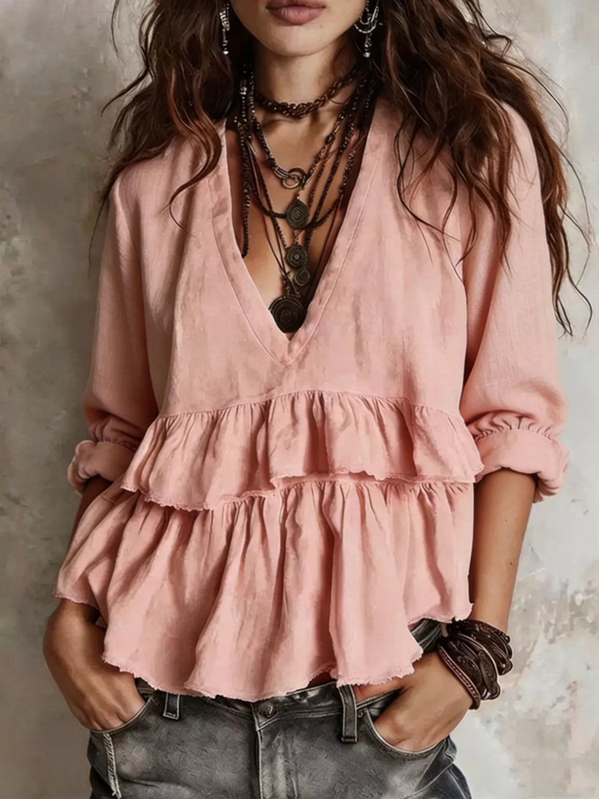 Pink ruffled V-neck blouse with tiered peplum hem and long puff sleeves