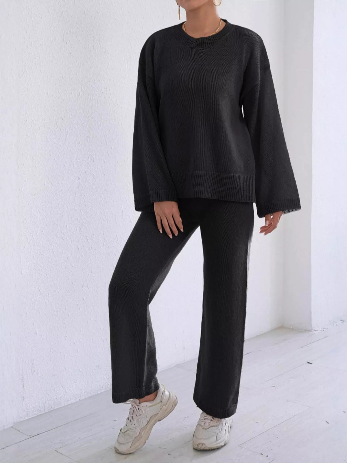 Black knit sweater and wide-leg pants set with long sleeves and ribbed trim at cuffs.