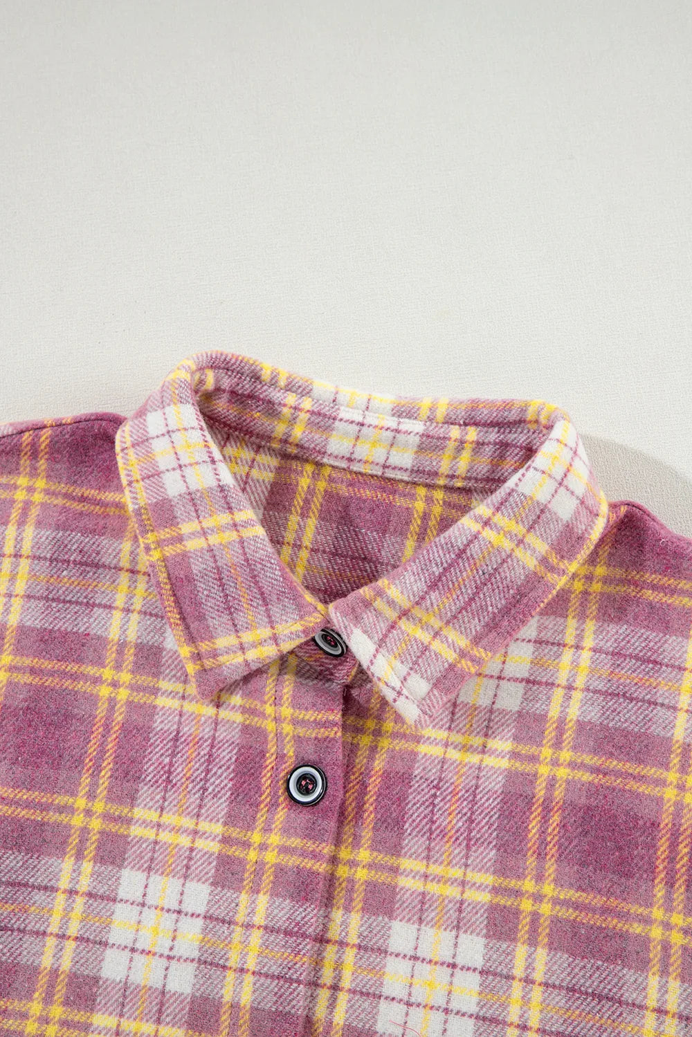Pink plaid shacket collar close-up with two-button front