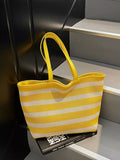 Yellow and white striped mesh shoulder bag with wide straps and open top