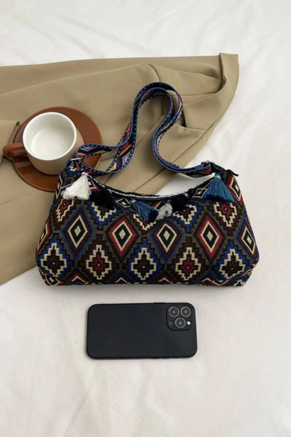 Geometric shoulder bag with tassel fringe and adjustable strap, navy with red and tan diamonds