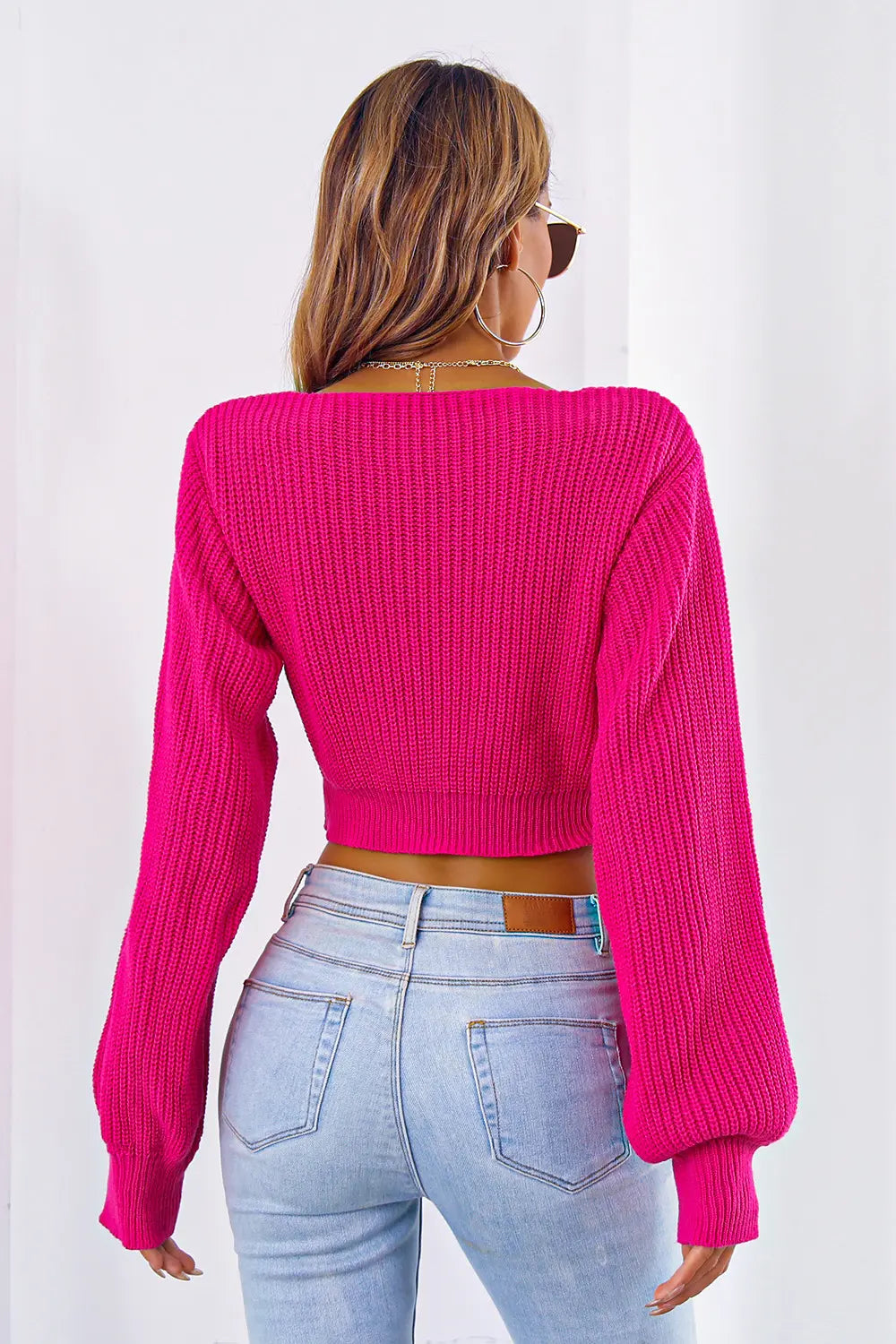 Deep rose knit cropped sweater with long sleeves; ribbed back and V-neck.