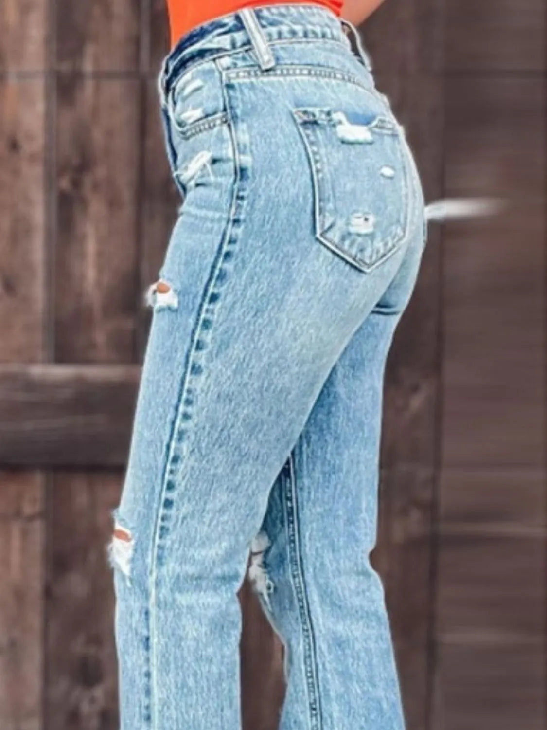 Light wash distressed slit bootcut jeans, back pockets with a side leg slit
