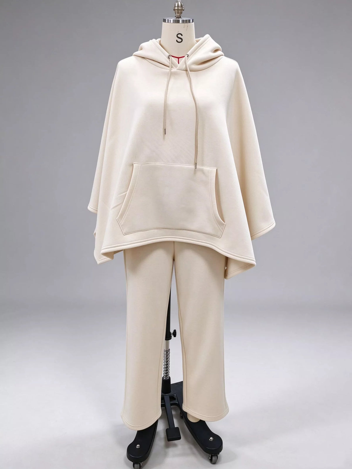 Beige hooded poncho with drawstring and front pocket over wide-leg pants set