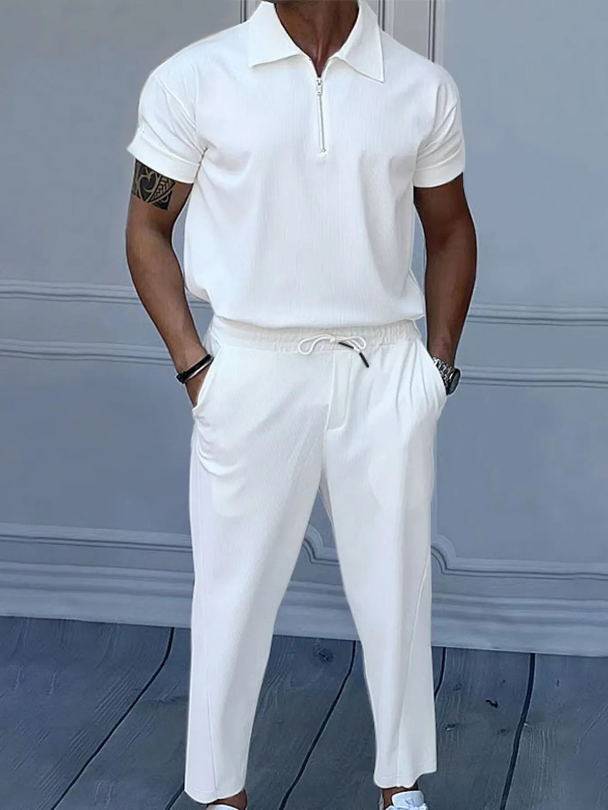 White quarter-zip polo and matching drawstring pants set on model