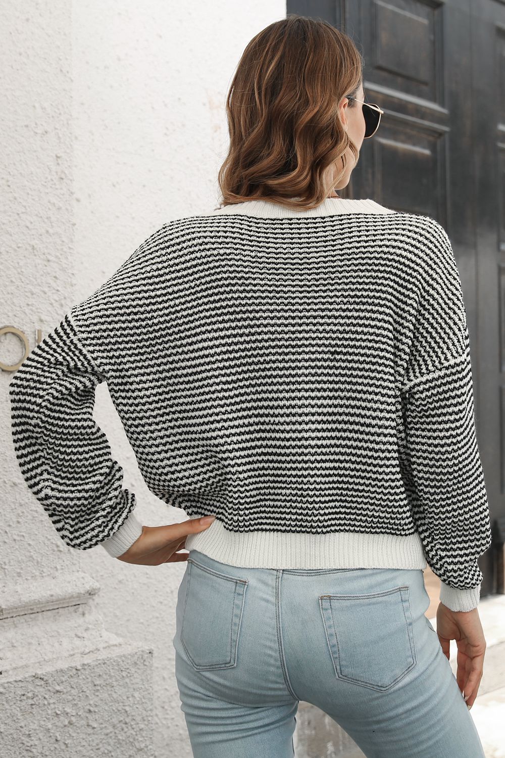 Black-and-white striped knit sweater with round neck and dropped shoulders, ribbed cuffs