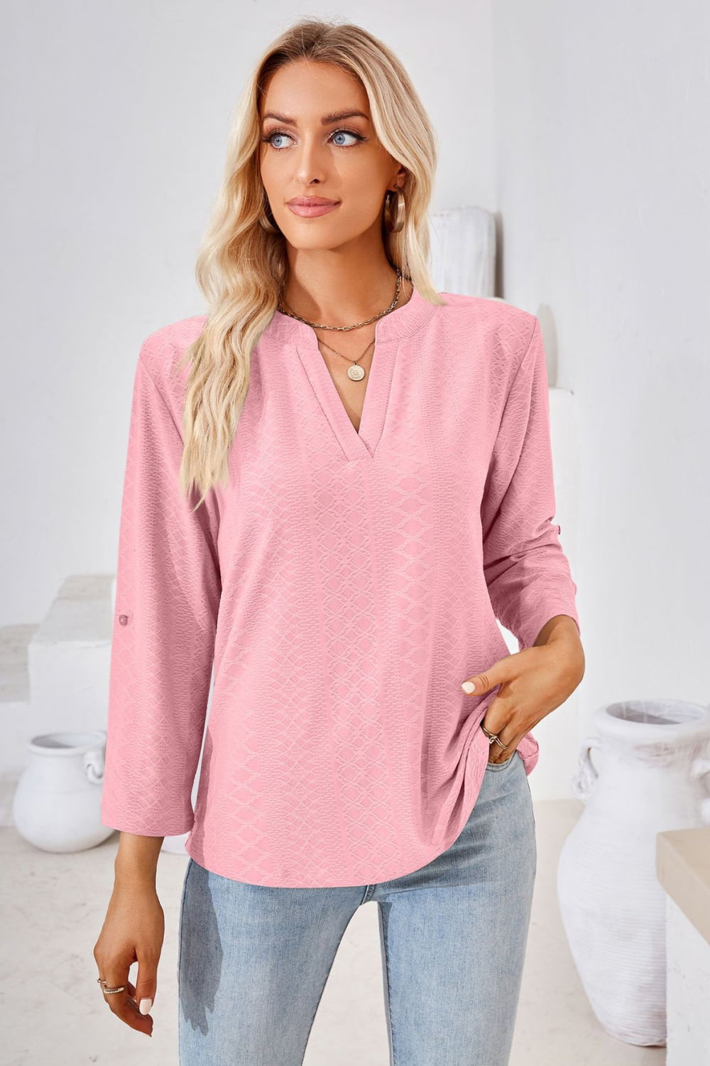 Dusty pink V-neck blouse with roll-tap sleeves and subtle textured diamond print.