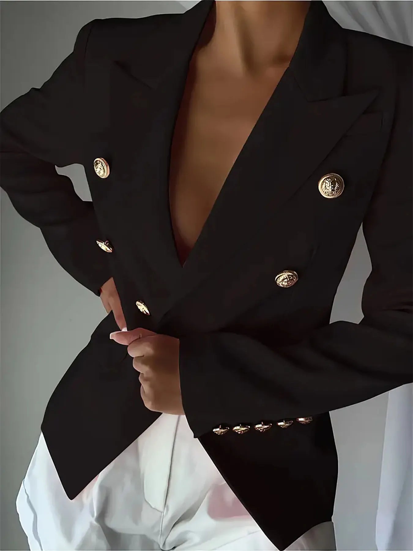 Black lapel blazer with gold-tone decorative buttons; fitted waist and long sleeves