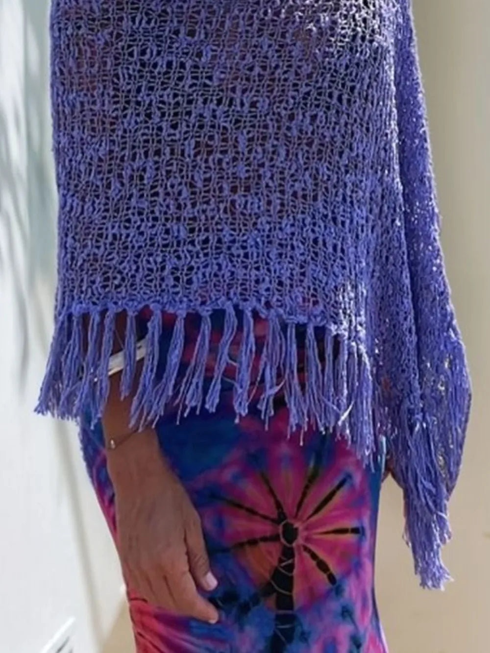 Purple open-knit shawl close-up with fringe tassels at bottom edge