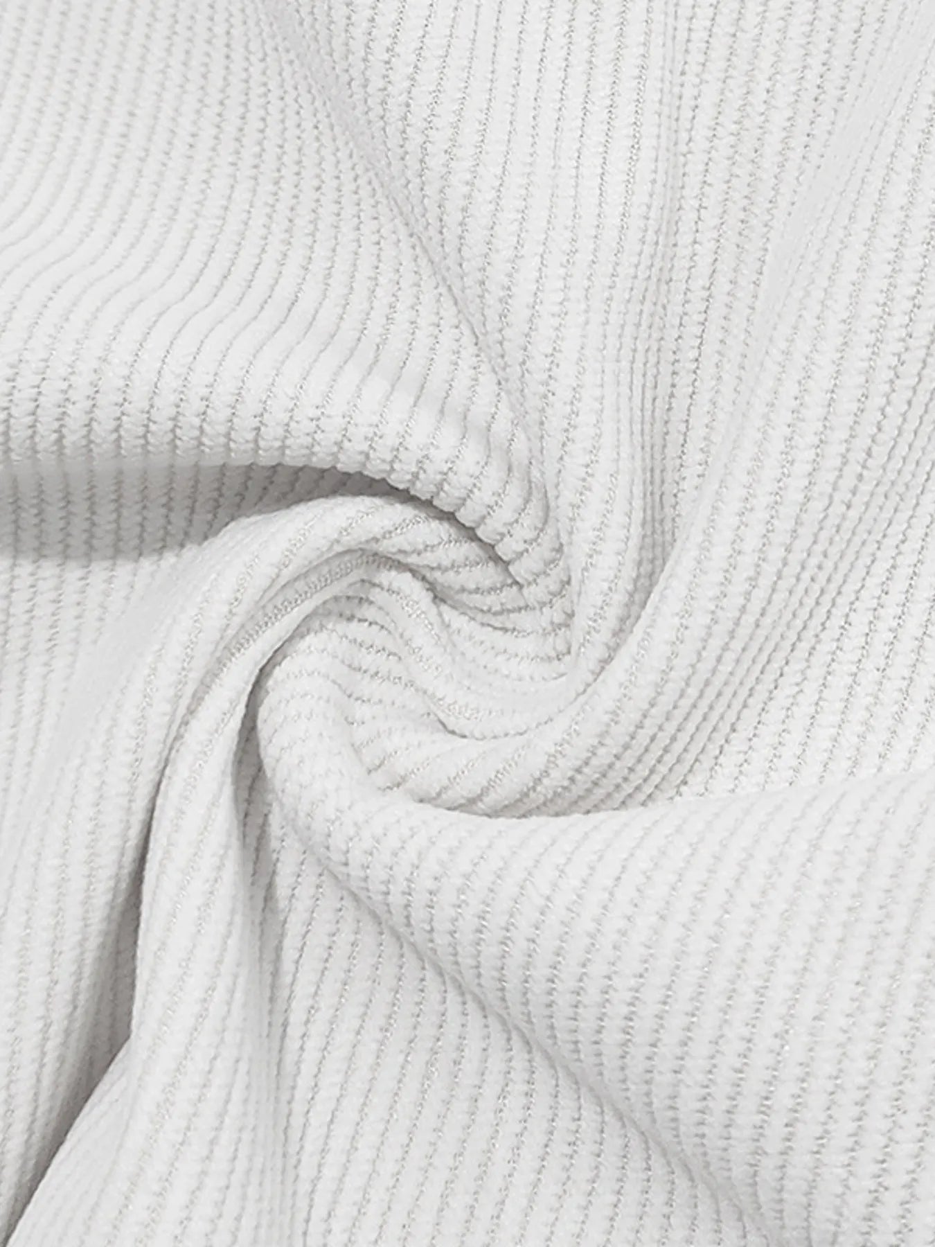 White ribbed knit fabric from the set, showing textured weave detail